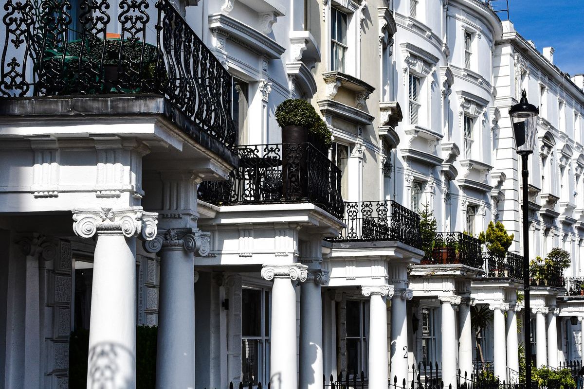 A row of white-fronted terraced houses with black railings