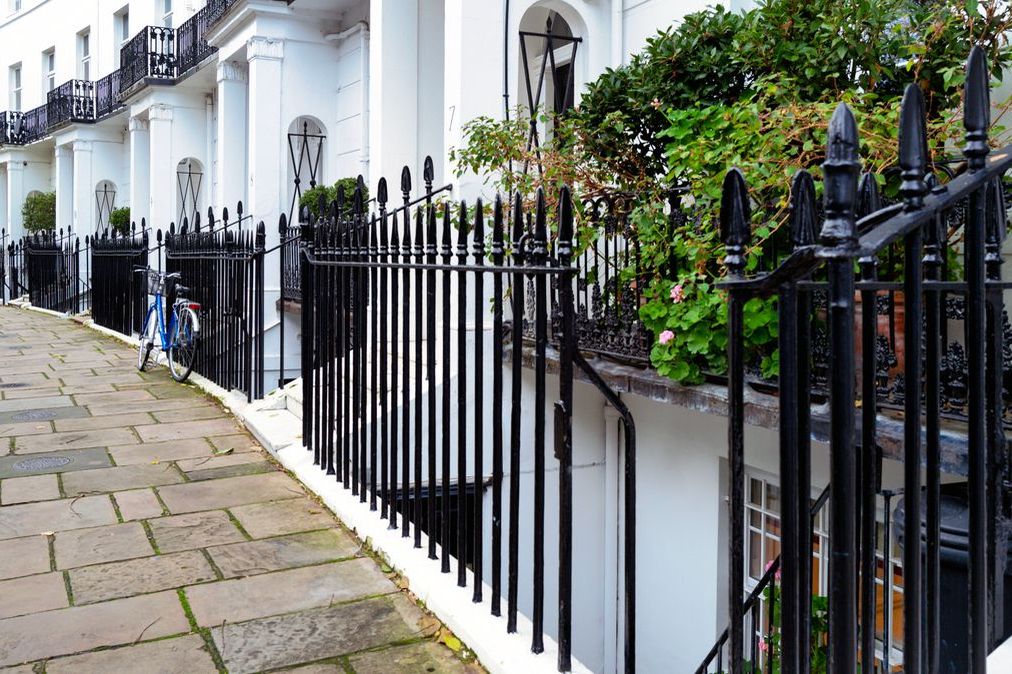 White stucco terraced houses with black railings