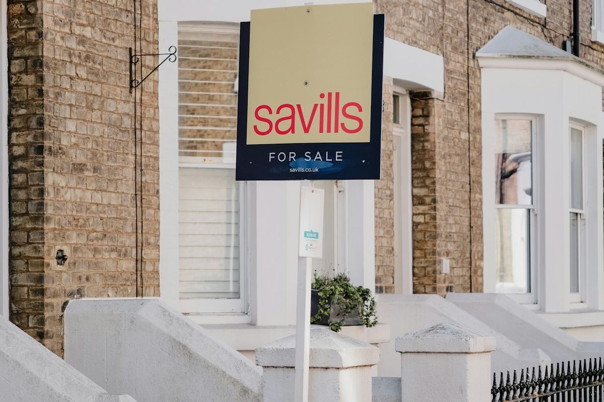 A for sale sign outside a terraced house